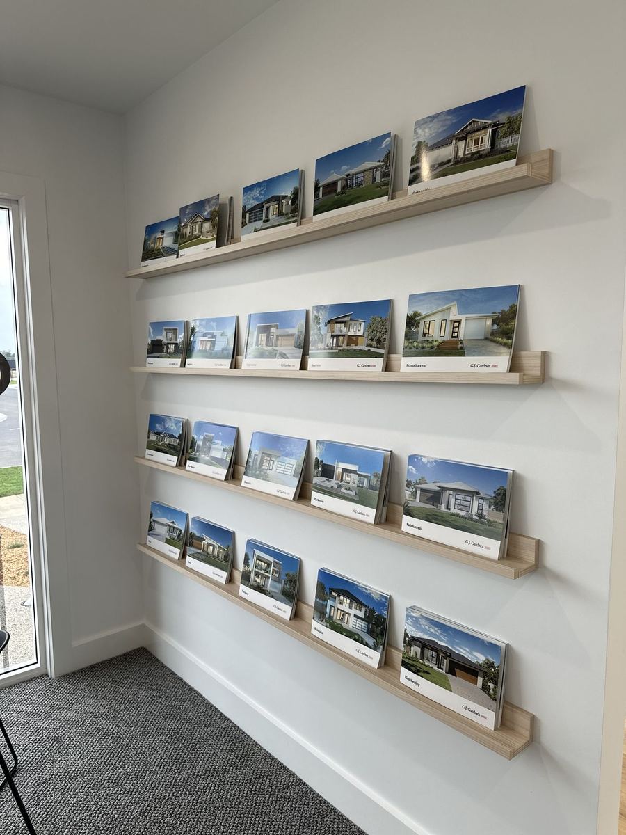 Wall-mounted brochure shelves in a GJ Gardner Homes sales office