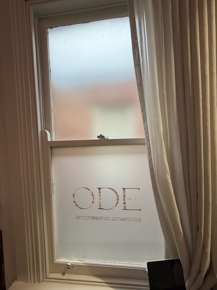 Frosted privacy film with a cut-out clinic logo on a sash window