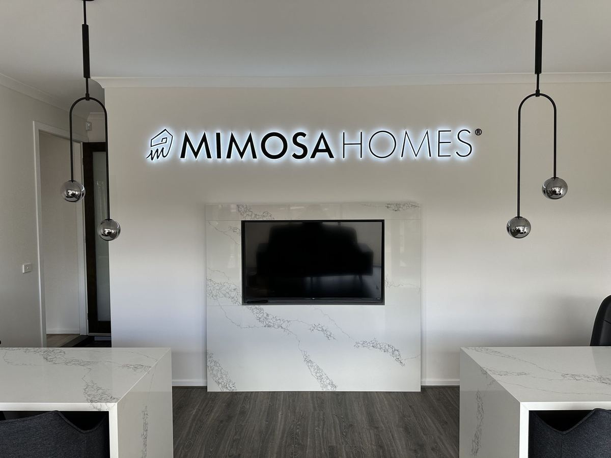 Mimosa Homes illuminated reception logo with pendant lights, front view