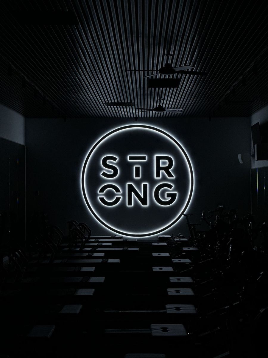 Illuminated LED Strong logo ring inside a dark fitness studio