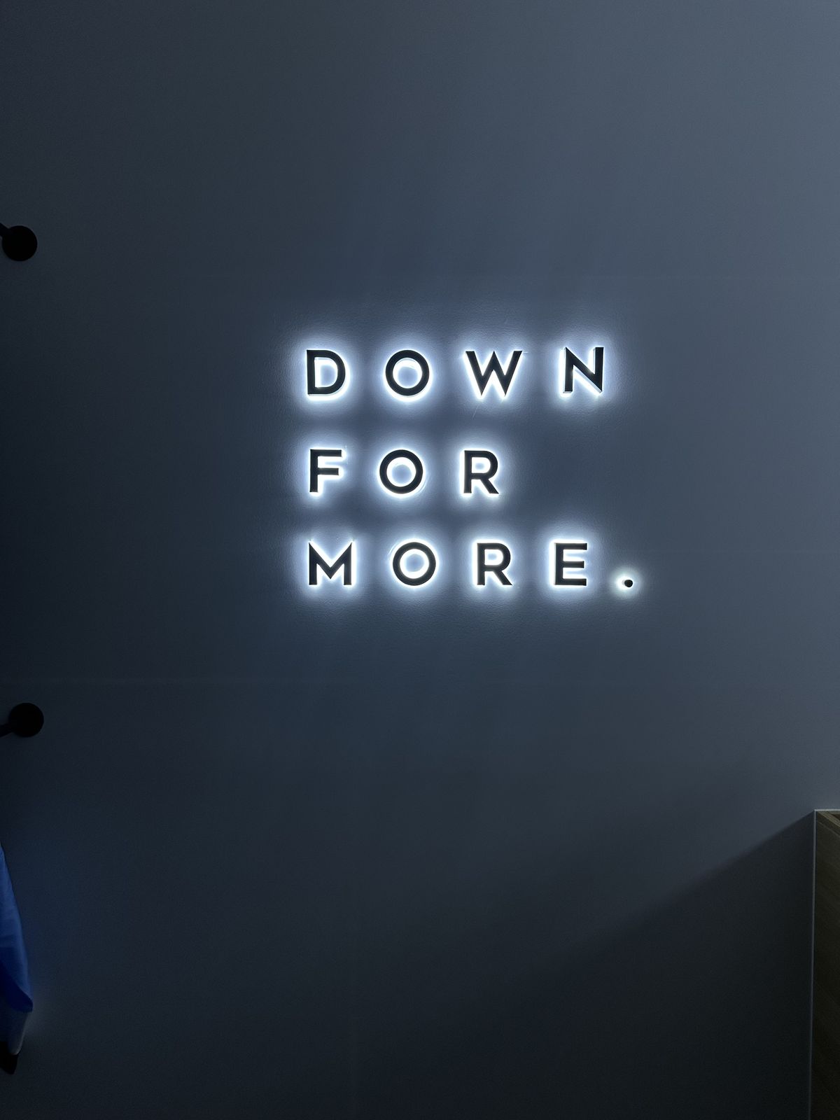 Illuminated Down For More lettering on a studio wall