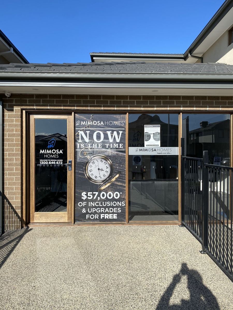 Mimosa Homes display suite entry with promotional window graphics