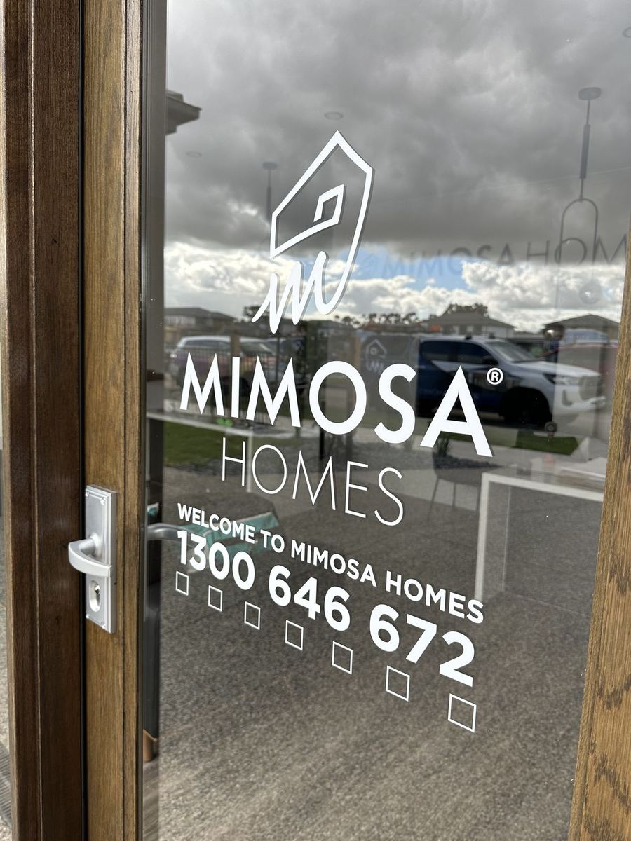 Mimosa Homes logo and phone number vinyl decal on a glass door