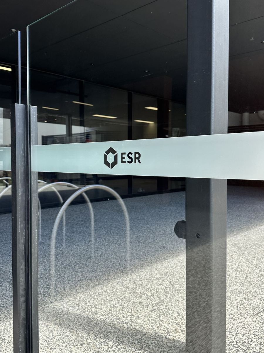 Frosted safety banding with the ESR logo on a glass door