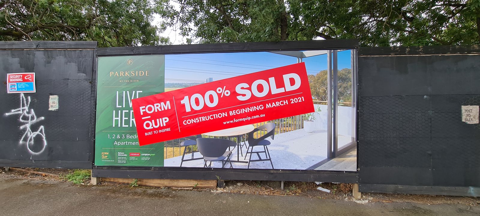 Printed hoarding banner with a 100% sold overlay on a construction fence