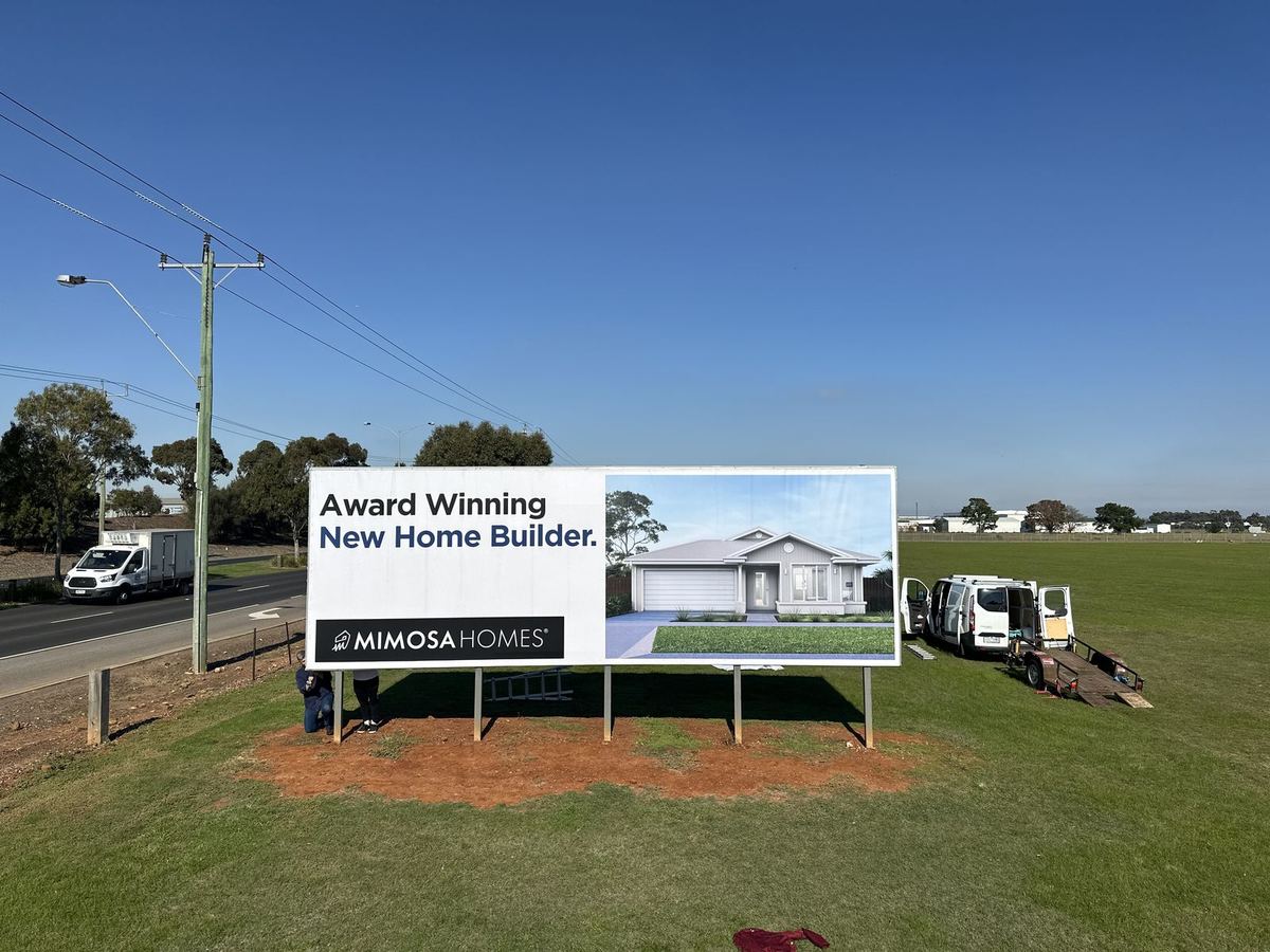 Mimosa Homes award banner billboard beside a road