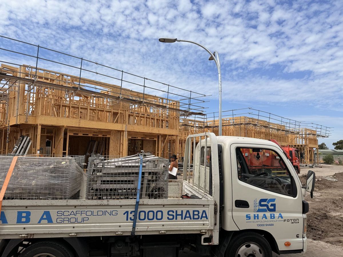 Shaba Scaffolding light truck with door and panel graphics on a building site