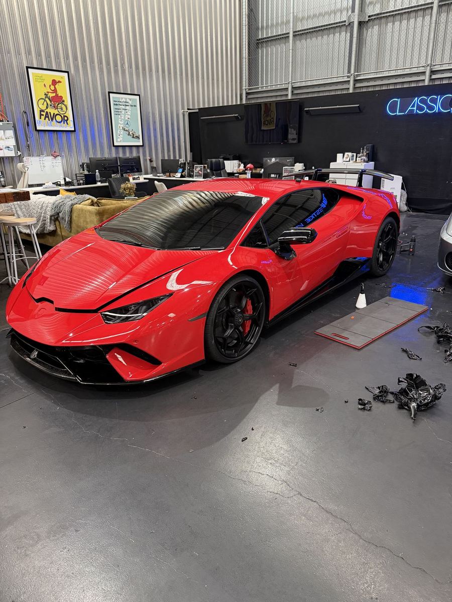 Red Ferrari with a full colour-change wrap in a workshop