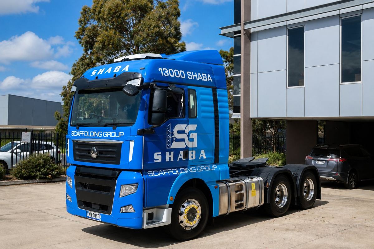 Blue branded livery and company lettering on a prime mover truck cab